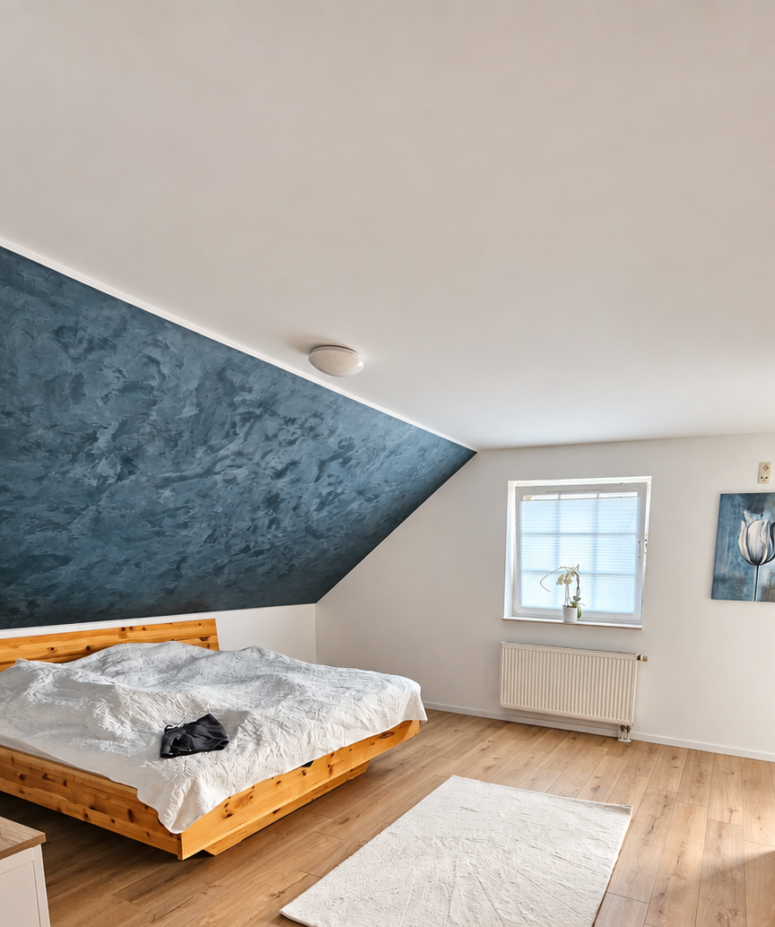Schlafzimmer mit blau gestalteter Dachschräge