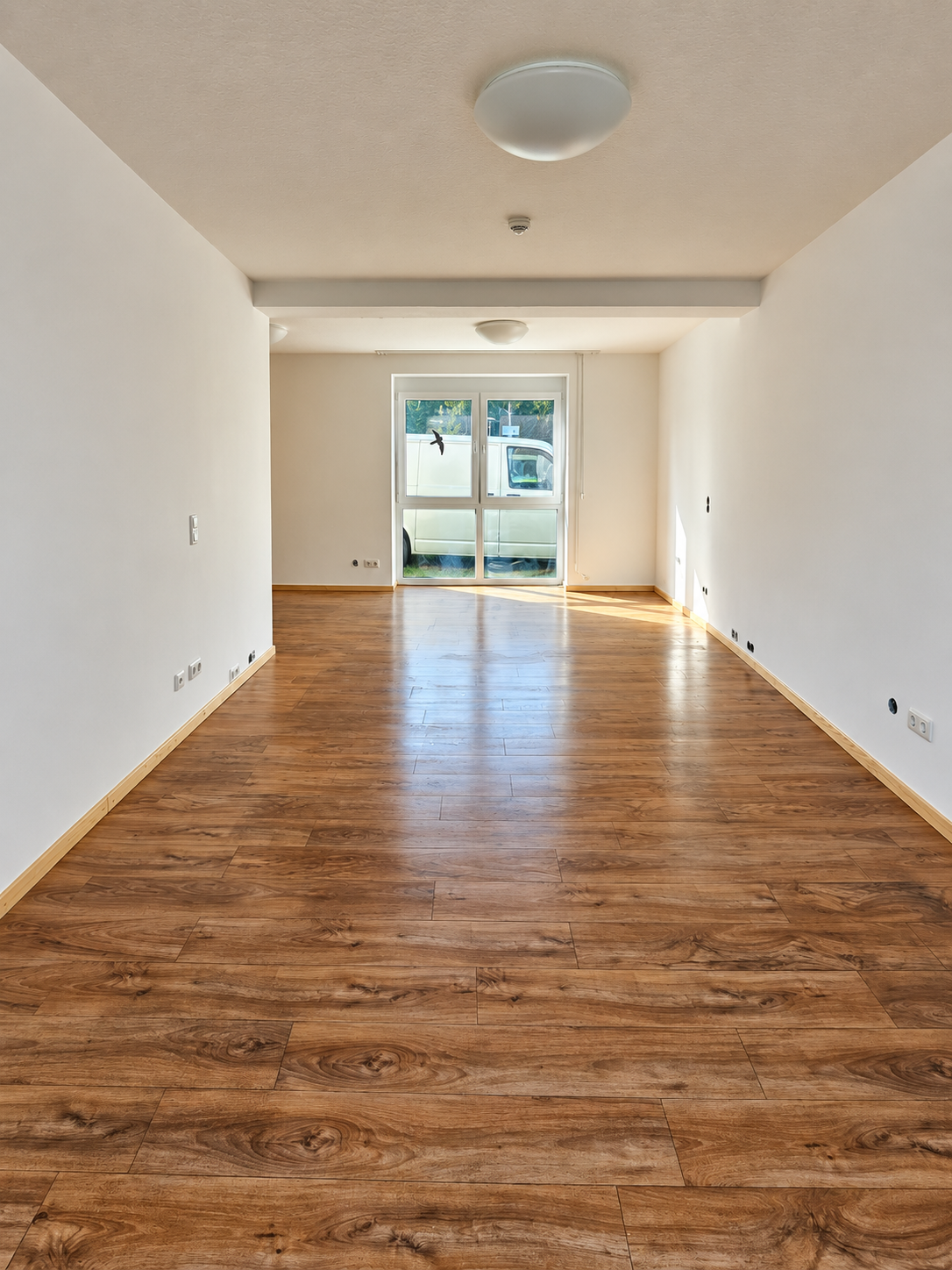 Langer Wohnraum mit Boden in Holzoptik