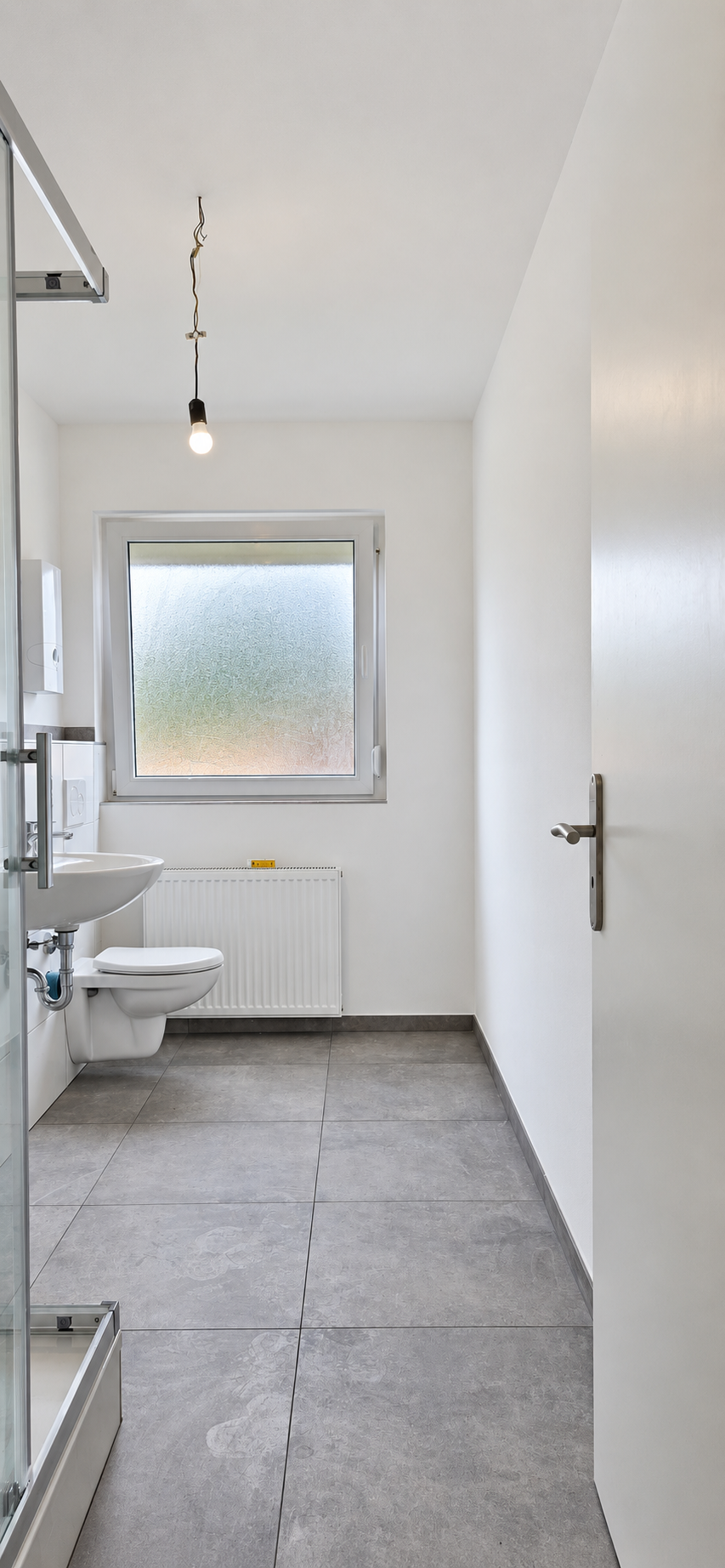 Helles Badezimmer mit grauem Boden